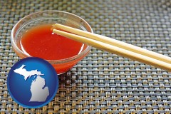 michigan map icon and chopsticks and red hot sauce in a Chinese restaurant