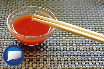 chopsticks and red hot sauce in a Chinese restaurant - with Connecticut icon