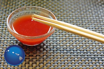 chopsticks and red hot sauce in a Chinese restaurant - with Hawaii icon