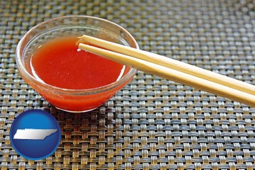 chopsticks and red hot sauce in a Chinese restaurant - with Tennessee icon